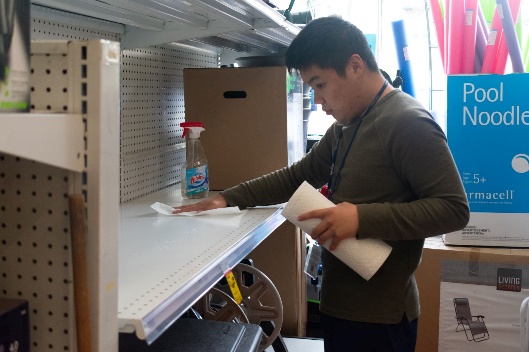 A person cleaning a shelfDescription automatically generated